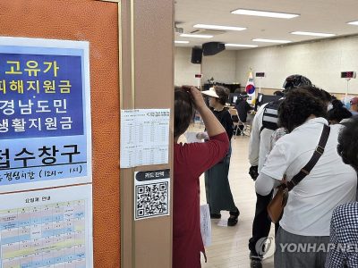 고유가 지원금 신청 첫날, 주민센터 앞에 줄선 시민과 안내 표지판이 보이는 현장 사진